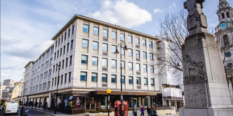  large building featuring a prominent clock on its facade, showcasing architectural details and timekeeping function.